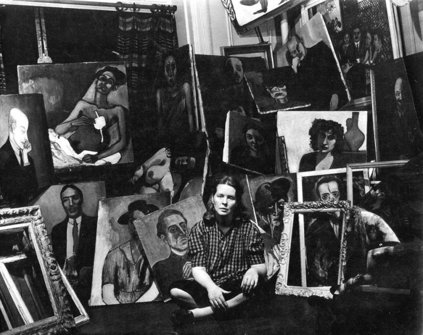 Photograph of Alice Neel sitting before her paintings which was used in the inviation to the exhibition